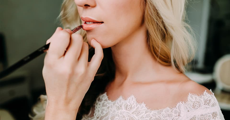 applying makeup on wedding bride