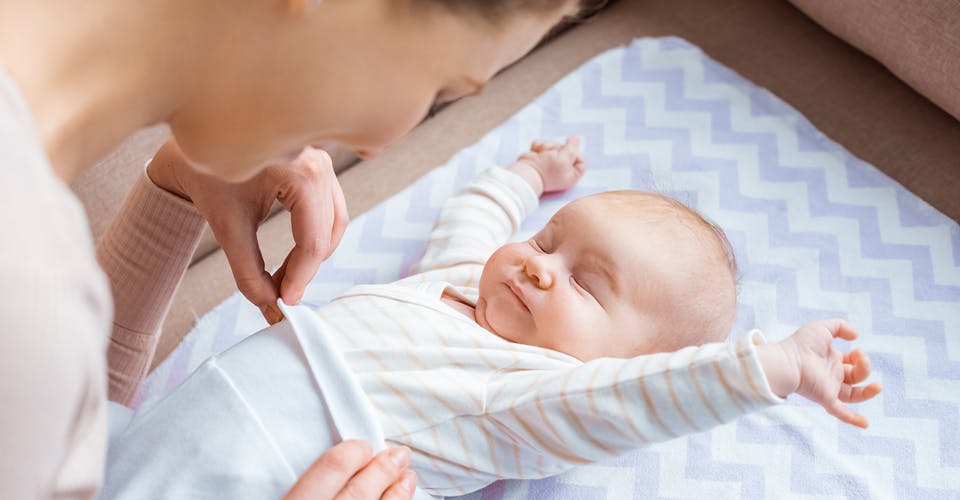 woman taking care of a baby on a changing table